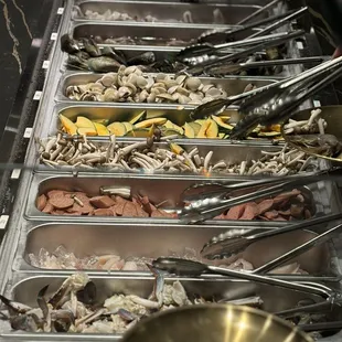 A nice selection of UNCOOKED foods and sauces for your shabu shabu / hot pot.