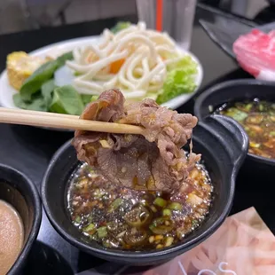 a bowl of soup with chopsticks