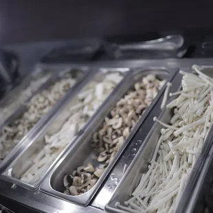 several trays of food being prepared