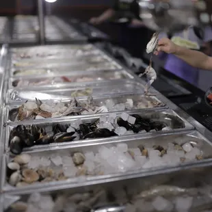 a woman serving seafood at a buffet