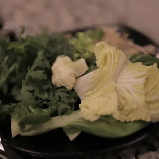 lettuce, cauliflower, and cauliflower florets on a black plate