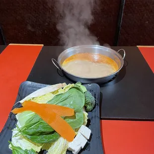 a plate of vegetables and a bowl of soup