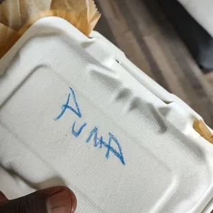 a hand holding a styrofoam container