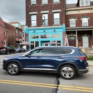 a blue suv driving down a street