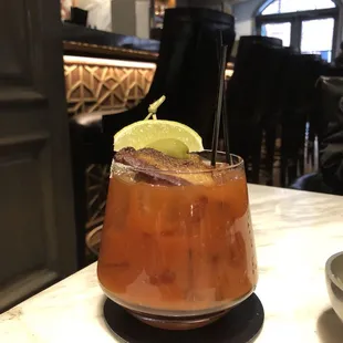 a cocktail with a lime garnish