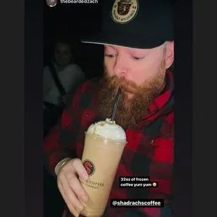 a bearded man drinking a drink