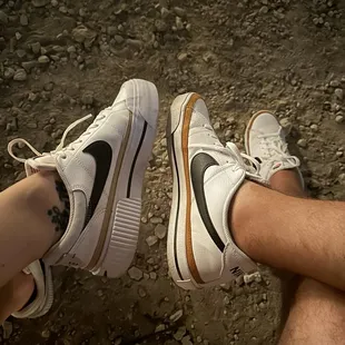 a man and a woman&apos;s legs with sneakers on