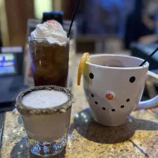 a cup of iced coffee and a snowman mug