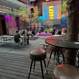 people sitting at tables and a screen