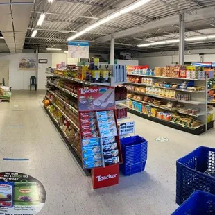 a grocery aisle with a shopping cart in the foreground
