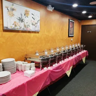 a long buffet table with plates of food