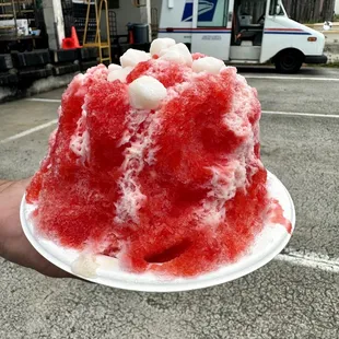 a hand holding a piece of cake