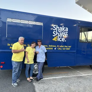 a family standing in front of a shaka shave ice truck