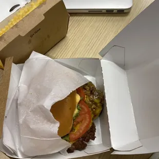 a hamburger in a take out box