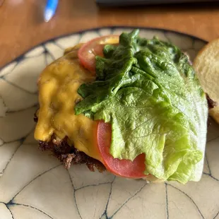 a cheeseburger with lettuce and tomato