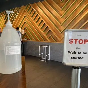 Hand sanitizer &amp; Stop to be seated sign as you enter the restaurant.
