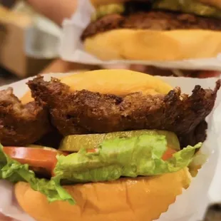 two burgers with lettuce and tomato
