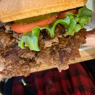 a hand holding a sandwich