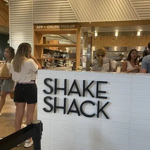 a woman standing in front of the shake shack