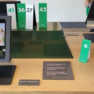 Place your order at the tablet then they'll text you when it's ready