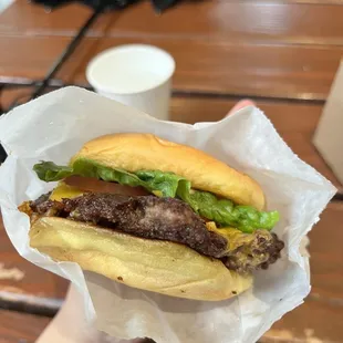 a hand holding a hamburger