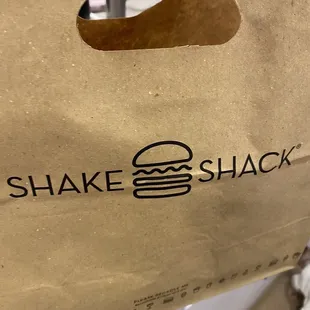 a paper bag with a burger inside