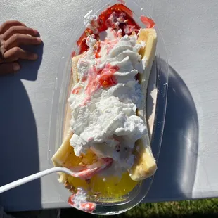 a banana split with whipped cream and strawberries