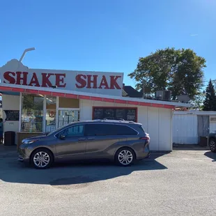 cars parked in front of a shake shack