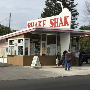 people standing in front of a shake shack