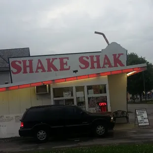 a black van parked in front of a shake shack