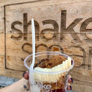 a hand holding a cup of ice cream