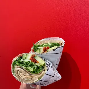 a hand holding a wrap of food