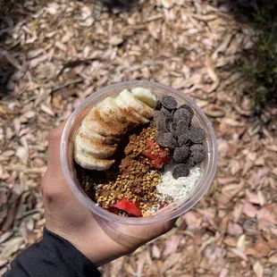 a person holding a bowl of smoothie