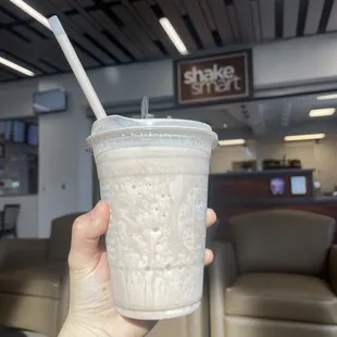 a hand holding a cup of milkshake