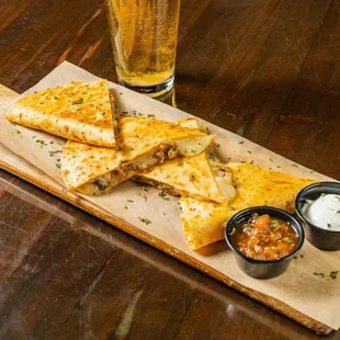 a plate of quesadillas and a glass of beer