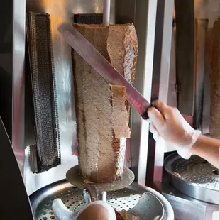 a person using a knife to cut a piece of bread