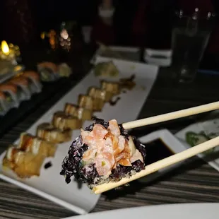 a plate of sushi with chopsticks