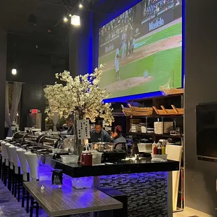 a bar with a large screen in the background