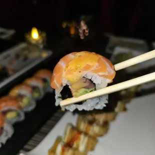 a sushi roll being held by chopsticks