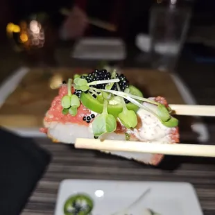 a piece of sushi being held by chopsticks