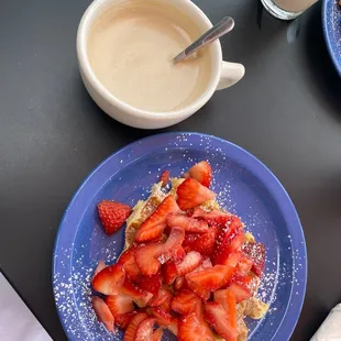 strawberries and powdered sugar on a blue plate