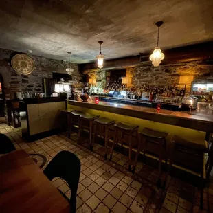 a dimly lit bar with stools