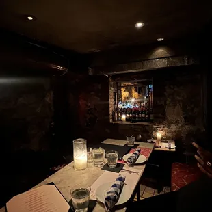 a dimly lit bar with candles and menus