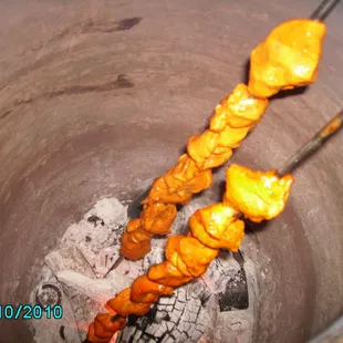 skewers of food being cooked