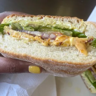 a hand holding a sandwich