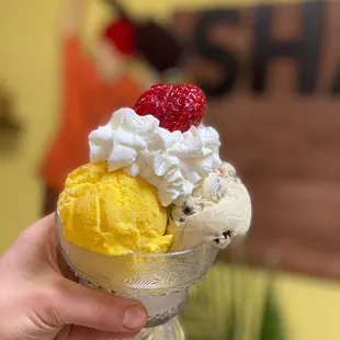 a hand holding a cup of ice cream