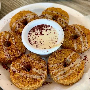 a plate of doughnuts with dipping sauce