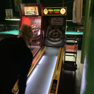 a woman playing a game of pinball