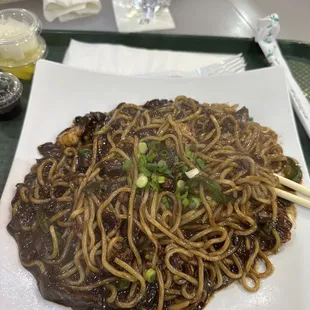 a plate of noodles and chopsticks