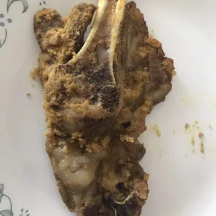 a white plate with a piece of meat on it